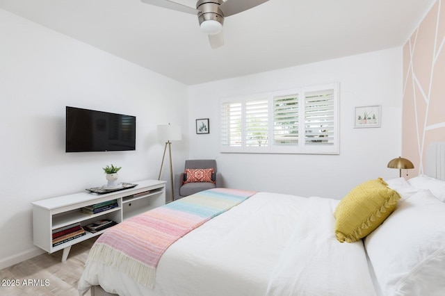 bedroom featuring baseboards, light wood-style flooring, and a ceiling fan
