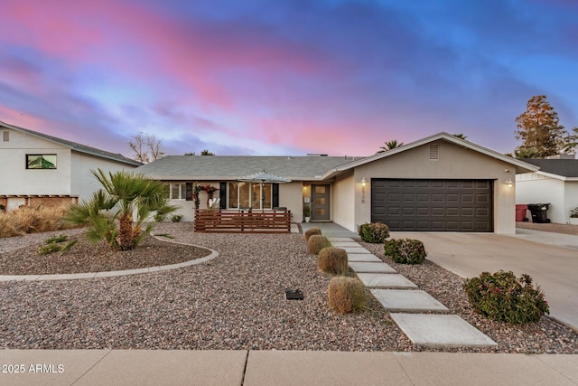 ranch-style house with stucco siding, driveway, and a garage