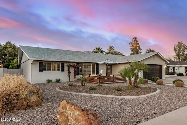 ranch-style home with stucco siding, driveway, and a garage