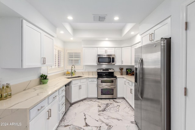 kitchen with appliances with stainless steel finishes, visible vents, a sink, and white cabinetry