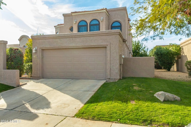 mediterranean / spanish-style home featuring a garage, concrete driveway, a front lawn, and stucco siding