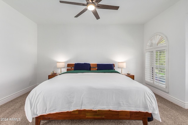 bedroom with ceiling fan, baseboards, and light colored carpet