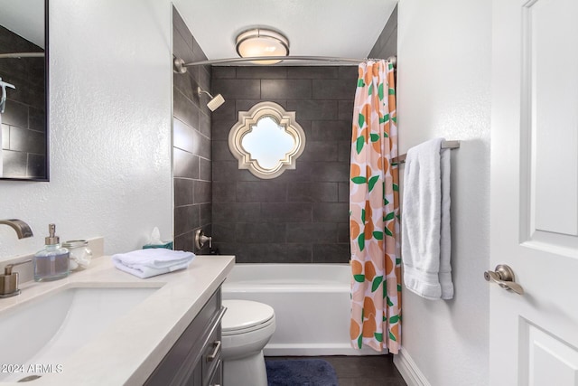 full bathroom featuring shower / tub combo with curtain, a textured wall, toilet, vanity, and baseboards