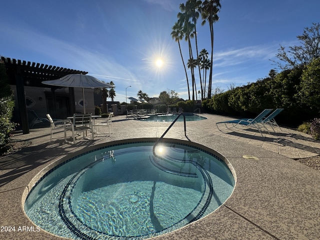 community pool featuring a community hot tub and a patio area