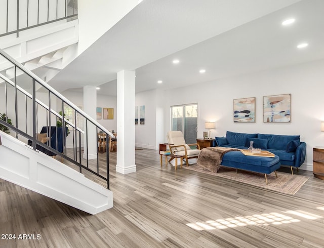 living area with stairs, baseboards, wood finished floors, and recessed lighting