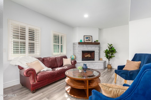 living area with light wood-style floors, a fireplace, baseboards, and recessed lighting