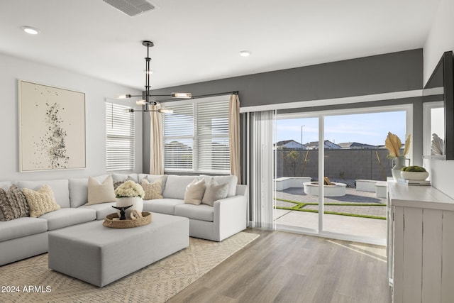 living room featuring light hardwood / wood-style flooring and an inviting chandelier