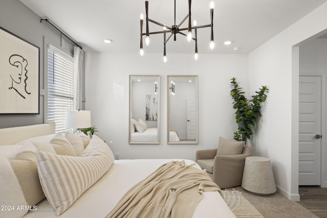 bedroom with wood-type flooring and an inviting chandelier