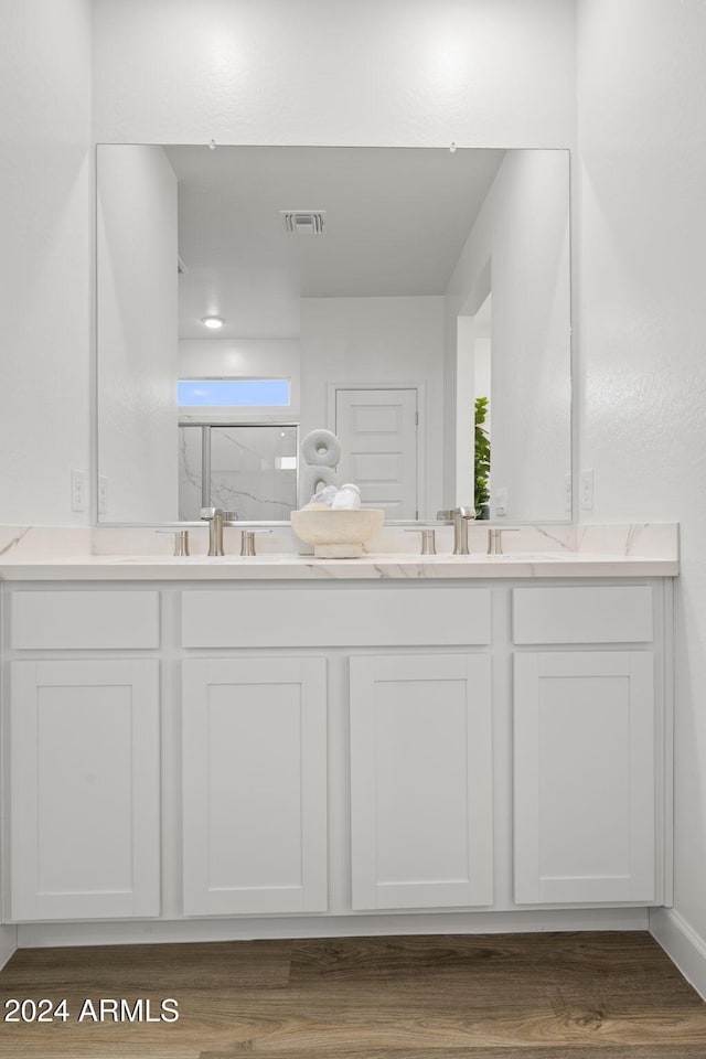 bathroom with a shower with door, vanity, and hardwood / wood-style flooring