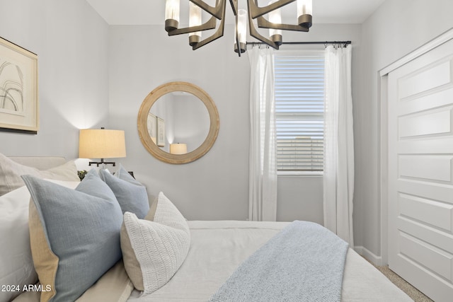 carpeted bedroom featuring a chandelier