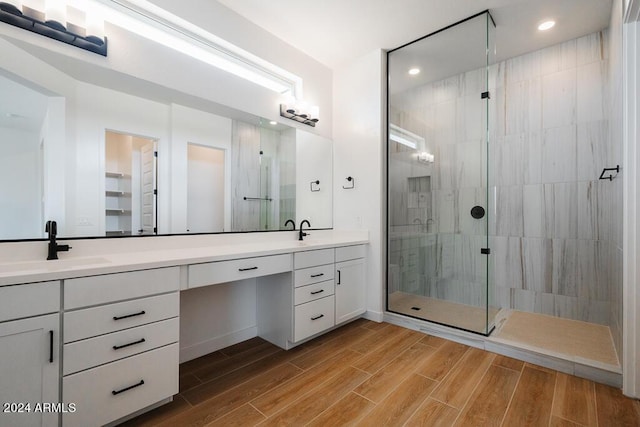 bathroom with a tile shower and vanity