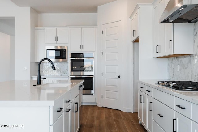 kitchen with white cabinets, wall chimney exhaust hood, sink, and stainless steel appliances