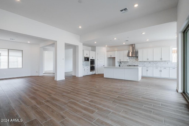 unfurnished living room featuring light wood-type flooring and sink