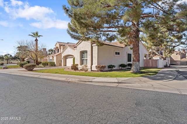 mediterranean / spanish house featuring a garage and a front lawn