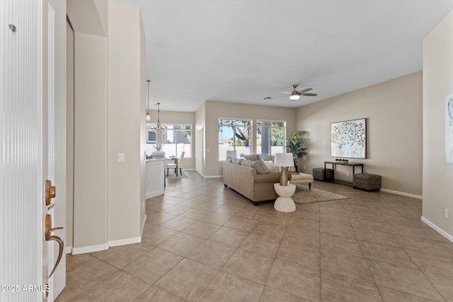 living room featuring light tile patterned flooring and ceiling fan with notable chandelier