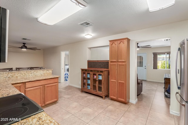 538 E Estevan Ave, Apache Junction, AZ 85119 - kitchen featuring a ceiling fan, freestanding refrigerator, light tile patterned flooring, a textured ceiling, and stovetop