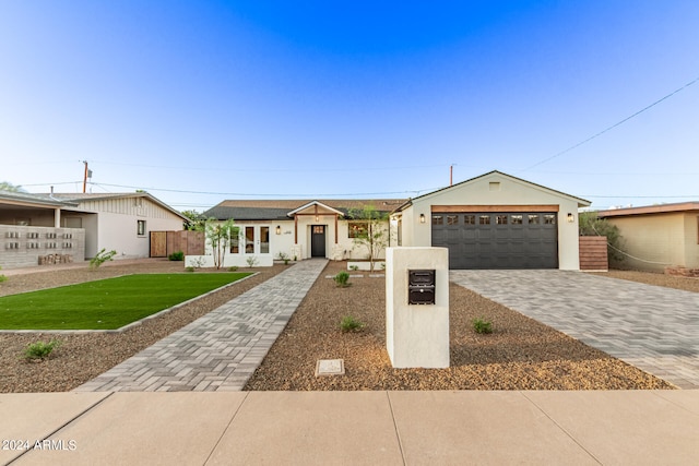 ranch-style home featuring a garage and a front yard