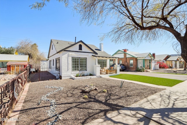 bungalow-style house with brick siding and fence