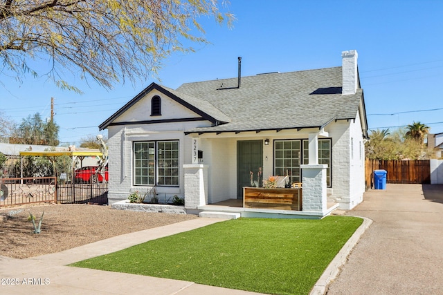 bungalow-style house with a chimney, a porch, roof with shingles, fence, and a front lawn