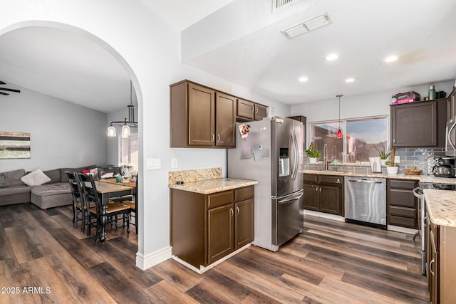 9169 W Ludlow Dr W, Peoria, AZ 85381 - kitchen with open floor plan, stainless steel appliances, visible vents, arched walkways, and dark wood-style flooring