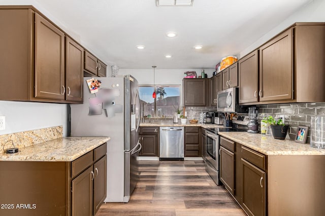 9169 W Ludlow Dr W, Peoria, AZ 85381 - kitchen with light stone countertops, decorative backsplash, appliances with stainless steel finishes, and dark wood-style flooring