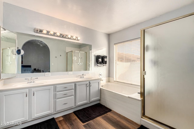 9169 W Ludlow Dr W, Peoria, AZ 85381 - bathroom featuring a shower stall, a sink, a garden tub, double vanity, and wood finished floors