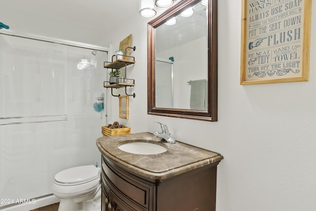 bathroom featuring vanity, an enclosed shower, and toilet