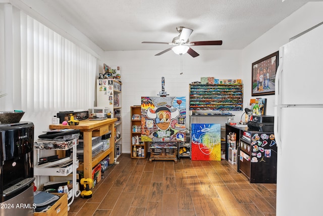 interior space with ceiling fan, dark wood-type flooring, and a textured ceiling