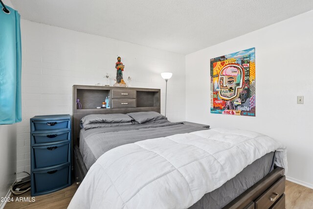 bedroom with hardwood / wood-style floors and a textured ceiling