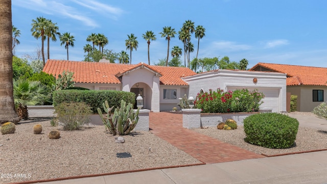8666 E Cheryl Dr, Scottsdale, AZ 85258 - mediterranean / spanish house with an attached garage, a chimney, stucco siding, and a tile roof