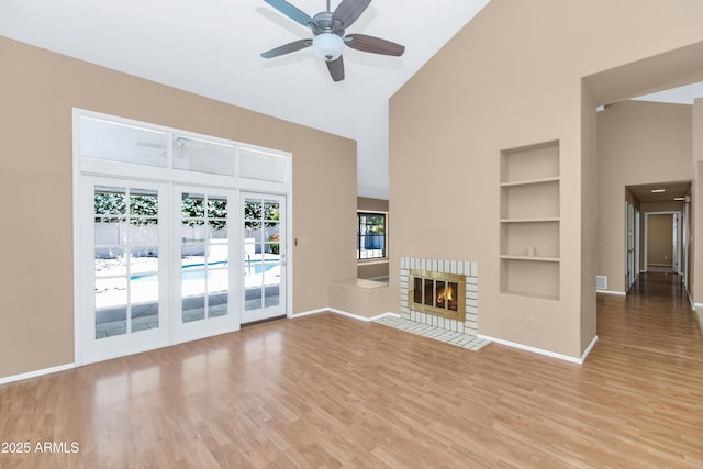8666 E Cheryl Dr, Scottsdale, AZ 85258 - unfurnished living room with baseboards, ceiling fan, high vaulted ceiling, light wood-type flooring, and built in shelves