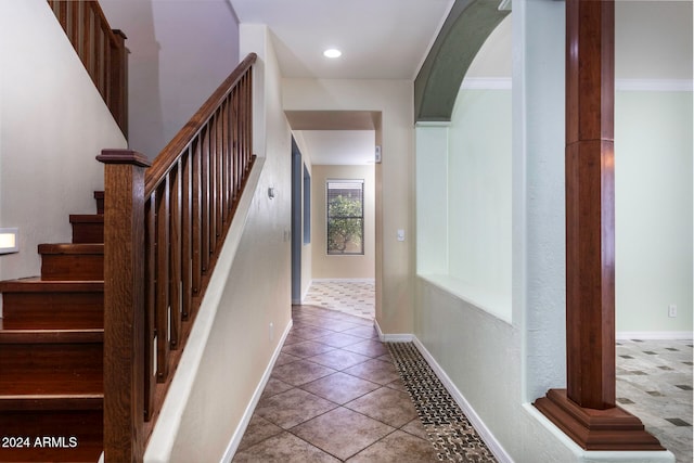 stairs featuring tile patterned floors and ornamental molding