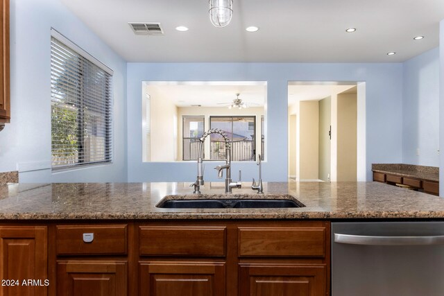 kitchen with light stone countertops, sink, ceiling fan, and stainless steel dishwasher