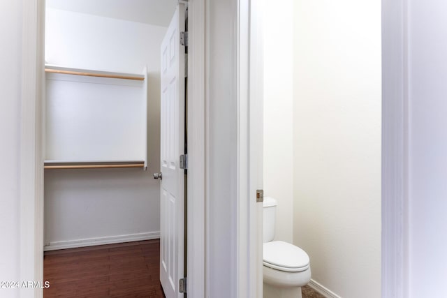 bathroom with hardwood / wood-style flooring and toilet