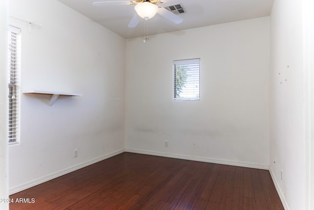 empty room with ceiling fan and dark wood-type flooring