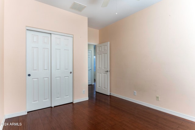 unfurnished bedroom featuring a closet, dark hardwood / wood-style floors, and ceiling fan