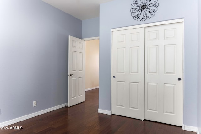 unfurnished bedroom featuring dark wood-type flooring and a closet