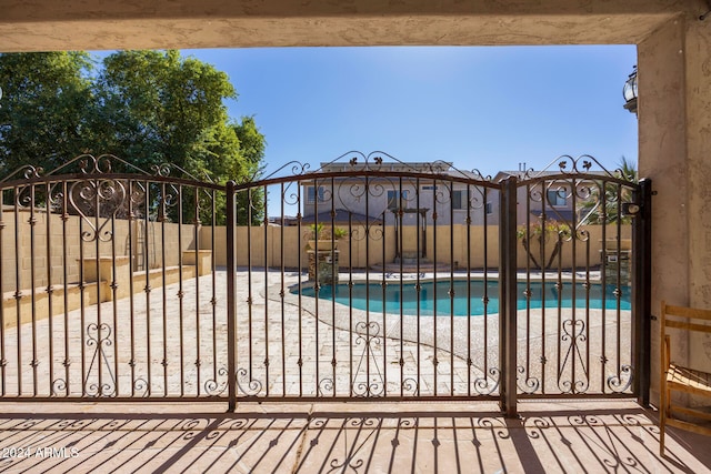 view of gate with a patio and a fenced in pool