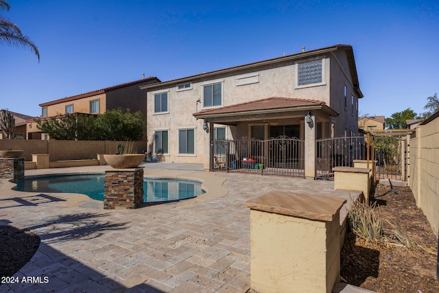 back of house featuring a fenced in pool, ceiling fan, and a patio