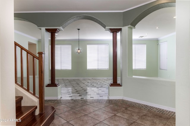 entryway with tile patterned floors, decorative columns, and ornamental molding