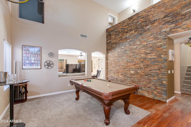 recreation room with a towering ceiling, billiards, light hardwood / wood-style floors, and ceiling fan