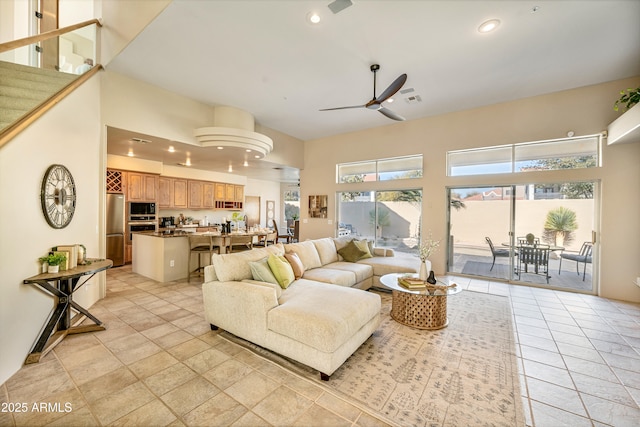 living room featuring ceiling fan, a towering ceiling, visible vents, and recessed lighting