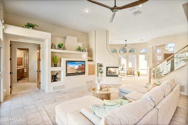 living area with recessed lighting, visible vents, a ceiling fan, and a multi sided fireplace