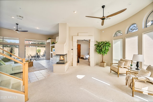 interior space featuring carpet floors, recessed lighting, visible vents, a ceiling fan, and a multi sided fireplace