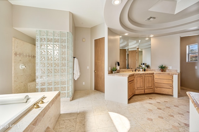 bathroom featuring visible vents, vanity, tiled tub, a walk in shower, and recessed lighting