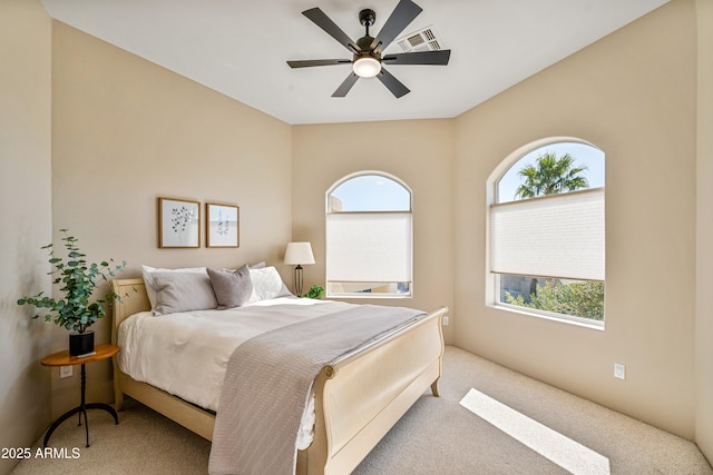 carpeted bedroom with ceiling fan and visible vents