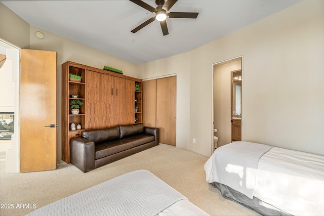 carpeted bedroom with a closet, ceiling fan, and ensuite bathroom