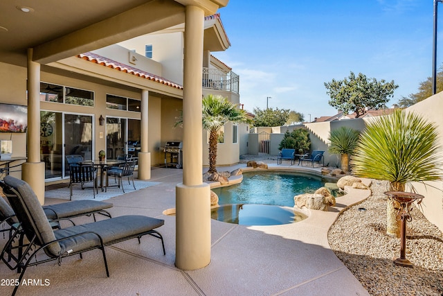 view of swimming pool featuring fence, area for grilling, a patio, and an in ground hot tub