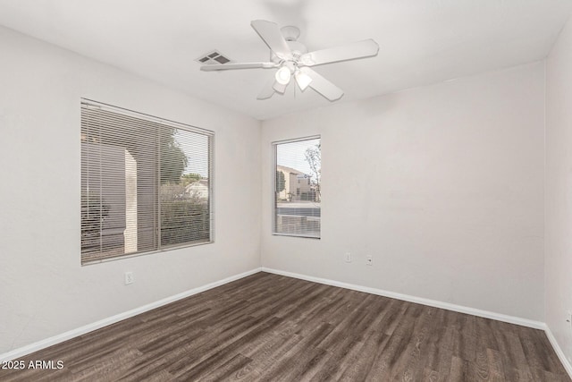 empty room with dark hardwood / wood-style flooring and ceiling fan