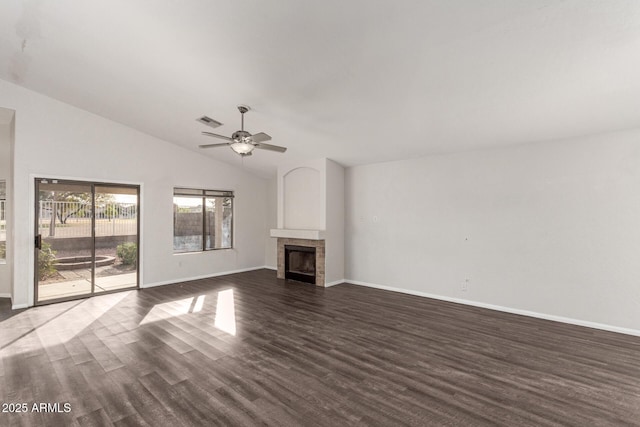 unfurnished living room with dark hardwood / wood-style flooring, ceiling fan, a fireplace, and vaulted ceiling